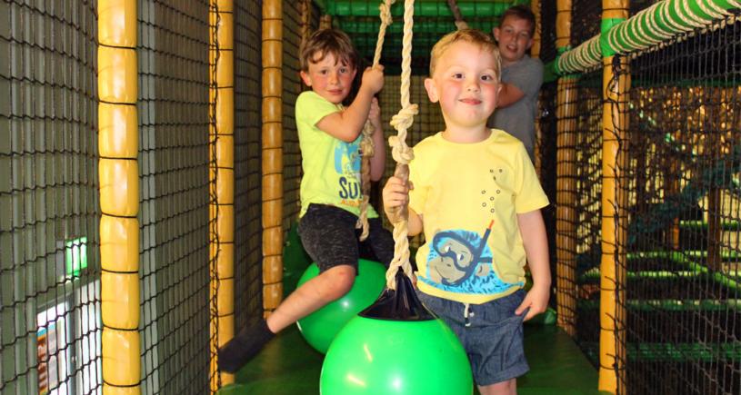 3 children play on the equipment at Safari Play, Peterborough.